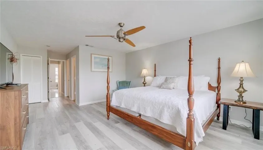 Bedroom with a closet, light wood-style floors, and ceiling fan