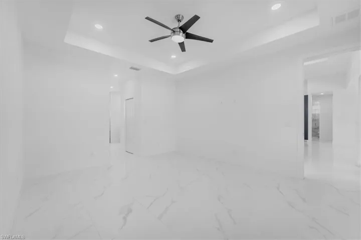 Detailed view of a raised ceiling, recessed lighting, and ceiling fan