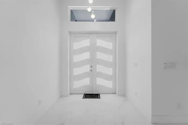 Foyer featuring light marble finish flooring and french doors