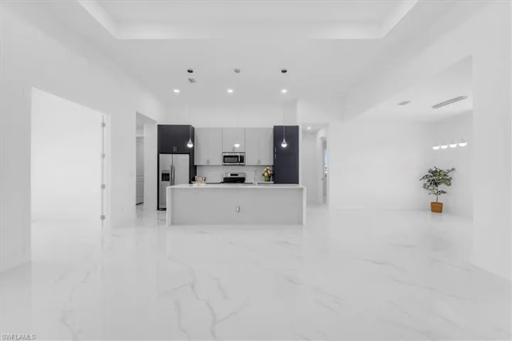 Unfurnished living room featuring a tray ceiling and recessed lighting