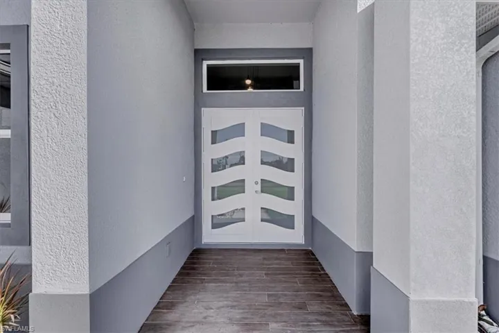 View of exterior entry with stucco siding and french doors
