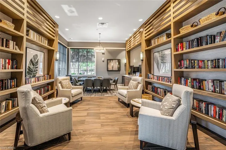 Living area featuring hardwood / wood-style floors, built in shelves, and crown molding