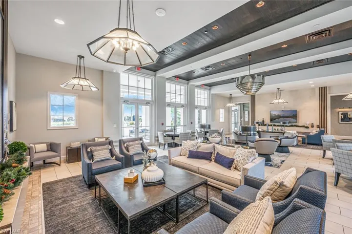 Tiled living room with a notable chandelier and a towering ceiling