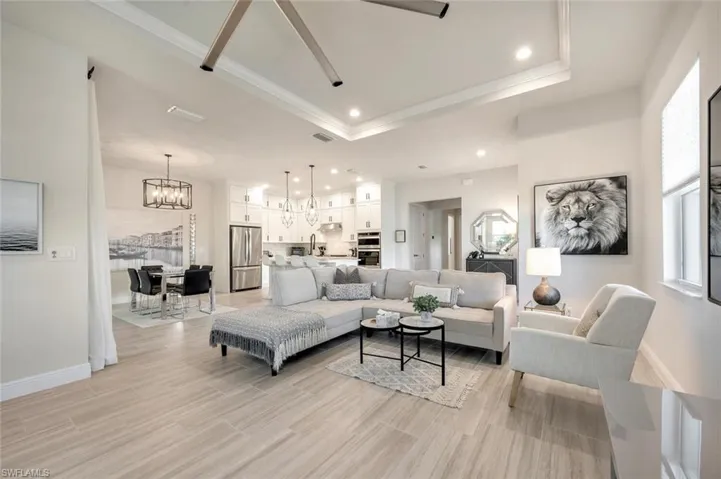 Living room featuring sink, a chandelier, and a tray ceiling