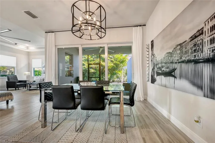 Dining area featuring light wood-type flooring and ceiling fan with notable chandelier