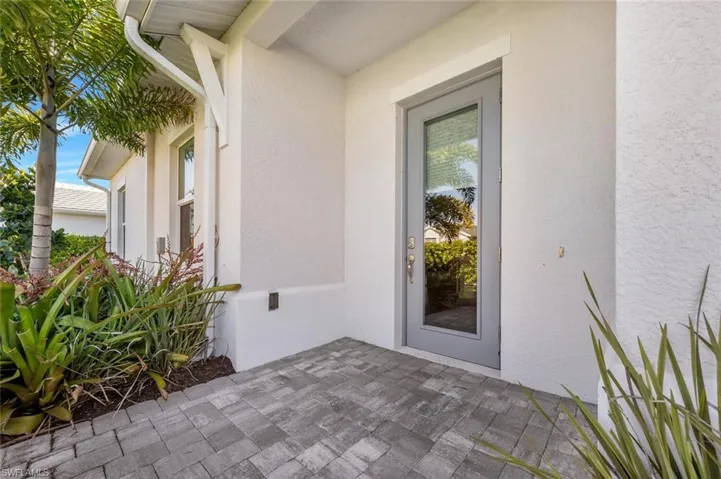 Private side entrance to property with a patio area