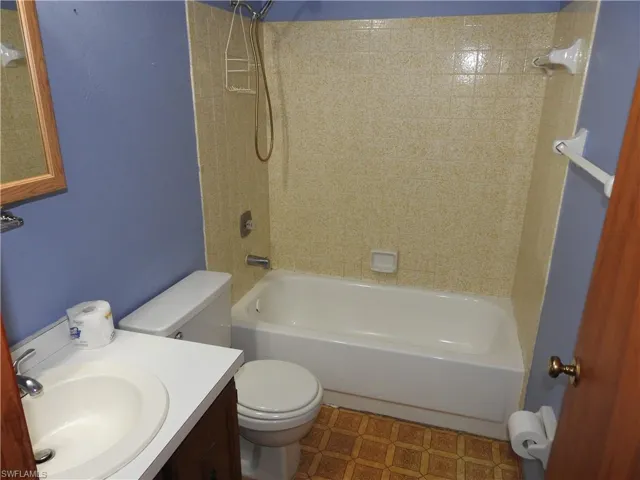 Full bathroom featuring vanity, toilet, and tiled shower / bath combo