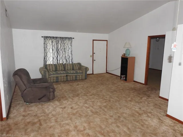 Carpeted living room with lofted ceiling