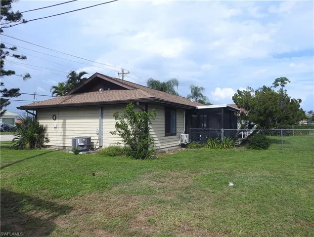 Back of property featuring a lawn and a sunroom