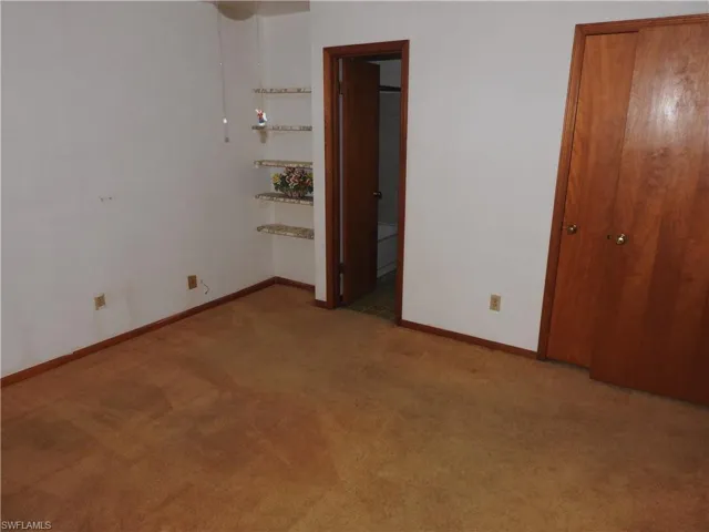Unfurnished bedroom featuring carpet and connected bathroom