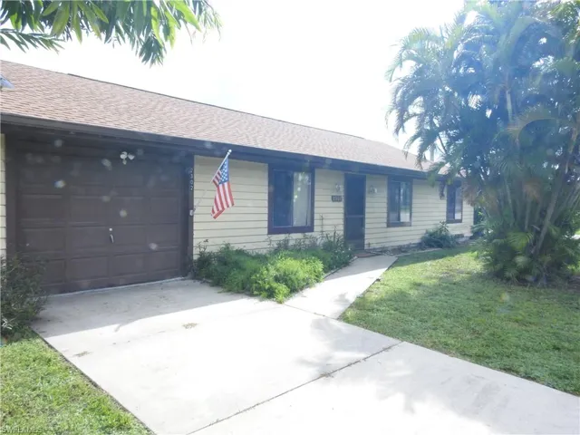 Ranch-style house with a garage and a front lawn