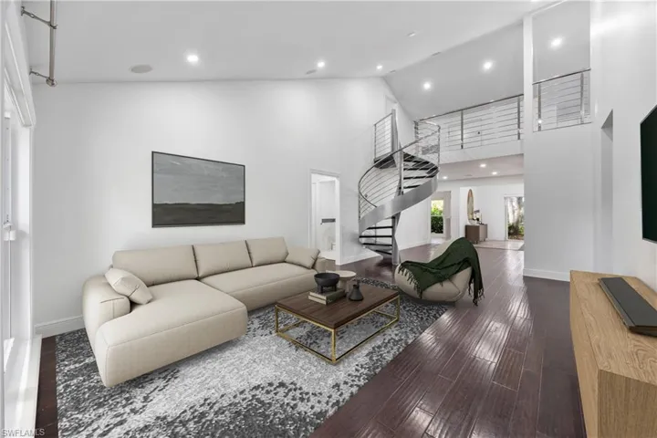 Living room featuring hardwood / wood-style floors and a high ceiling virtually staged
