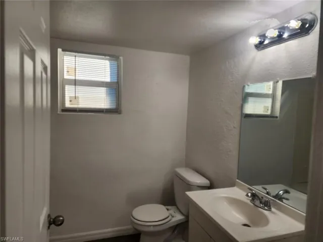 Bathroom with vanity and a textured wall