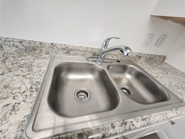 Kitchen view of a sink and a textured wall