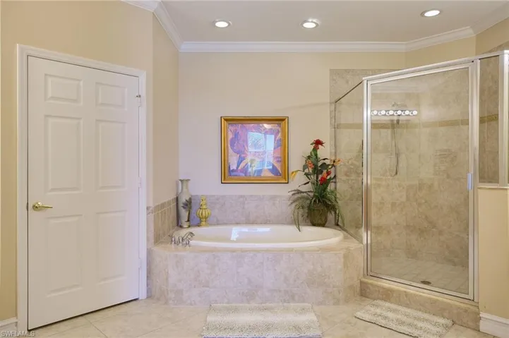 Bathroom with crown molding, tile patterned floors, and plus walk in shower