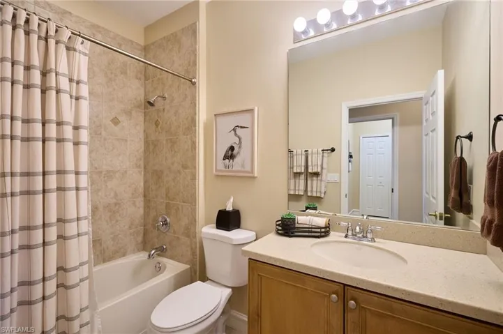 Full bathroom featuring vanity, shower / bath combination with curtain, and toilet