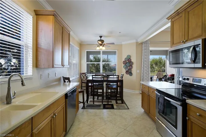 Kitchen featuring a healthy amount of sunlight, appliances with stainless steel finishes, sink, and crown molding