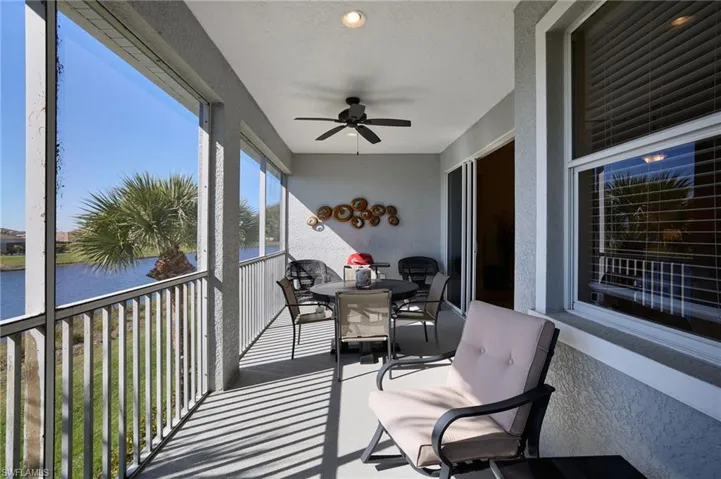 Sunroom featuring ceiling fan and a water view