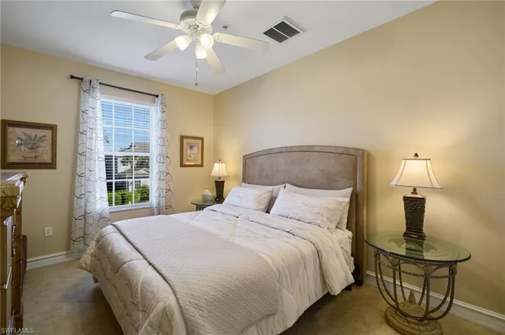 Tiled bedroom featuring ceiling fan