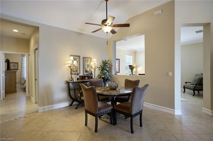 Dining space with crown molding, light tile patterned floors, and ceiling fan
