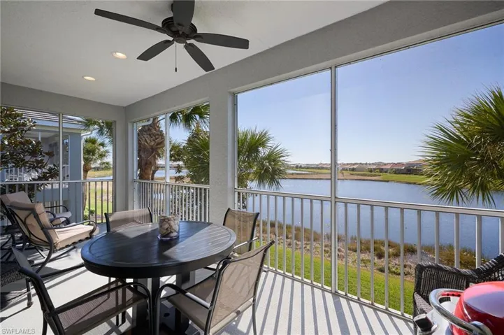 Sunroom with ceiling fan, a healthy amount of sunlight, and a water view