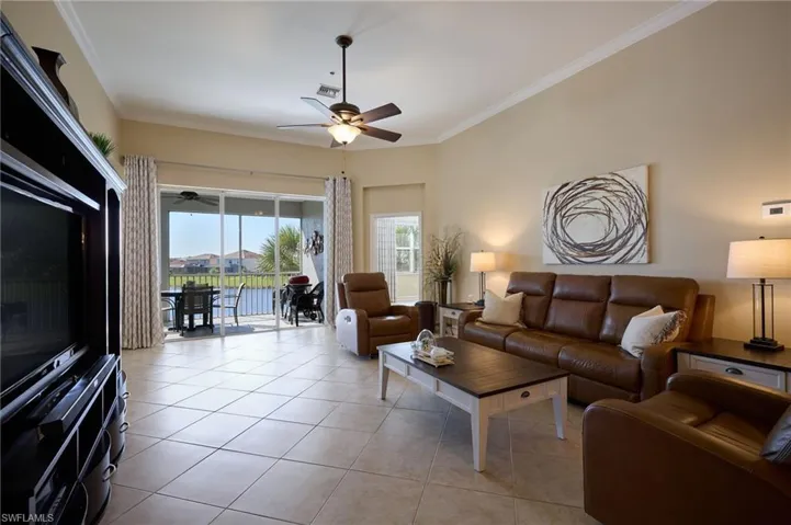 Tiled living room featuring crown molding and ceiling fan