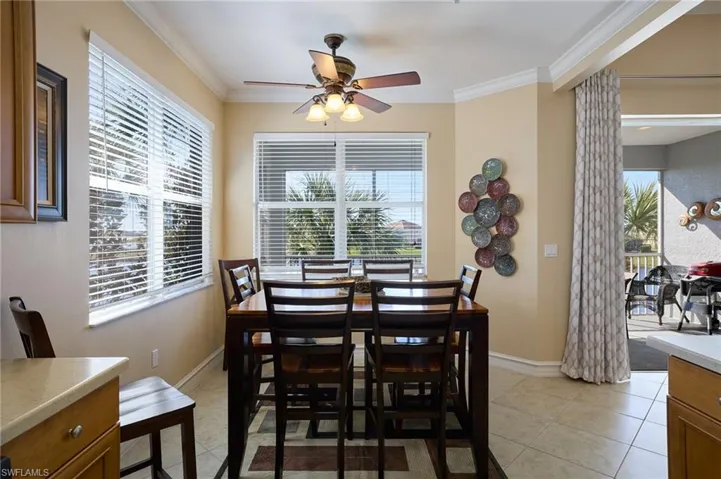 Tiled dining room featuring crown molding and ceiling fan