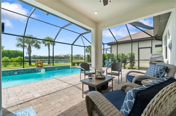 View of pool featuring a screen lanai, and pool water feature, a lake view