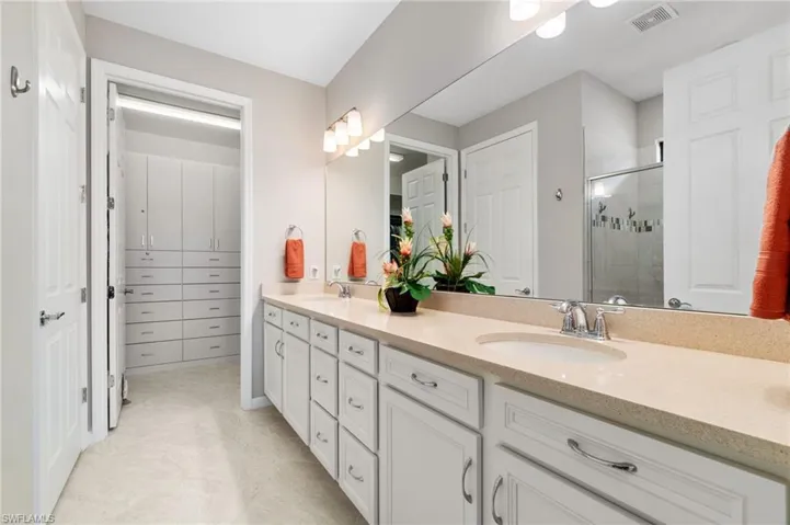 Dual sinks with quart counters and tons of storage cabinets and custom walk-in closet