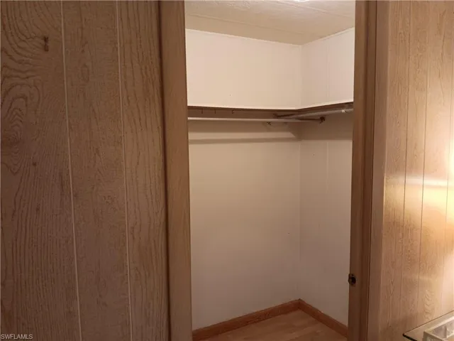 Walk in closet with light wood-style flooring