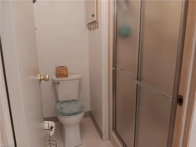 Full bathroom featuring toilet and a stall shower