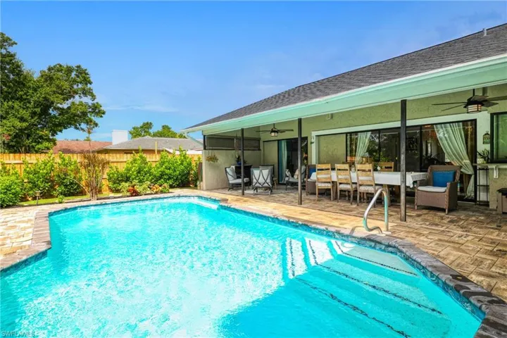 View of pool with ceiling fan and a patio