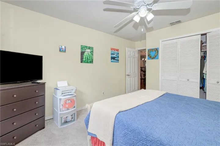 Carpeted bedroom featuring a closet and ceiling fan