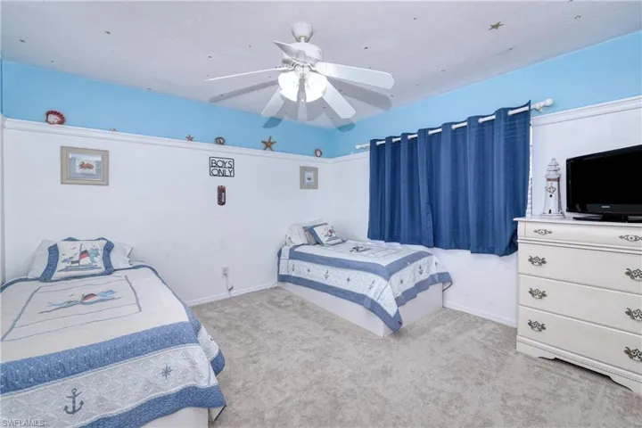 Carpeted bedroom featuring ceiling fan