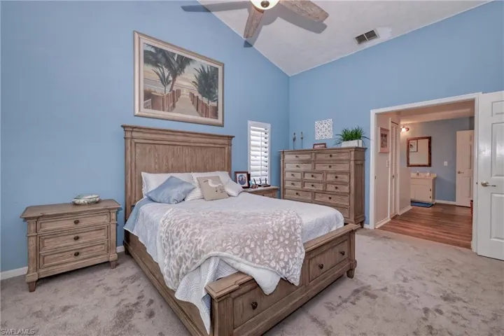 Bedroom with light carpet, high vaulted ceiling, and ceiling fan