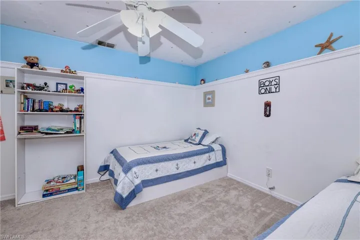 Bedroom with ceiling fan and light carpet