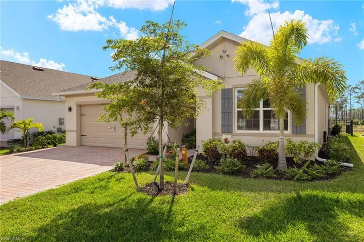 View of front of house with a garage, decorative driveway, stucco siding, and a front lawn