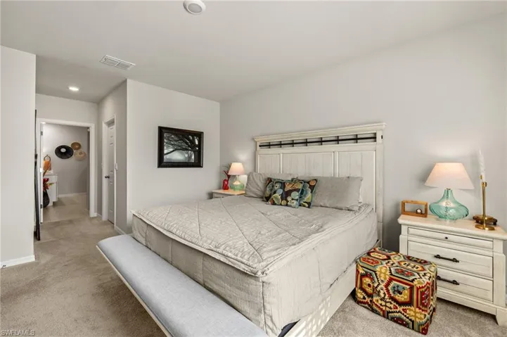 Primary Bedroom with carpet floors, baseboards, and visible vents