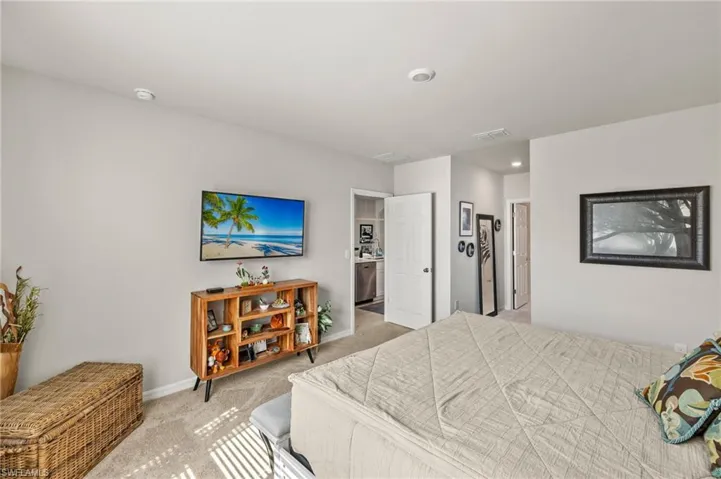 Bedroom with light carpet, baseboards, and visible vents
