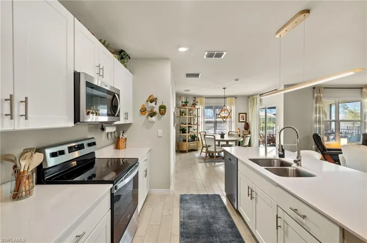 Kitchen with light countertops, visible vents, appliances with stainless steel finishes, a sink, and light wood-style floors