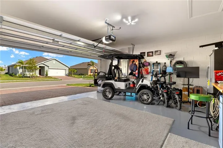 Garage featuring a garage door opener and concrete block wall