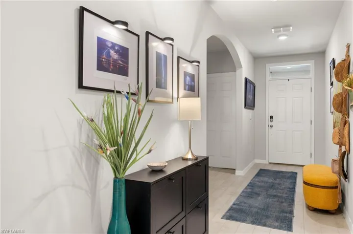 Entryway with arched walkways, baseboards, and visible vents
