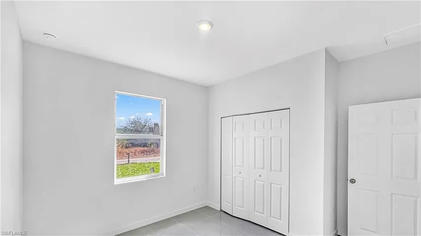 Unfurnished bedroom featuring light tile patterned floors and a closet