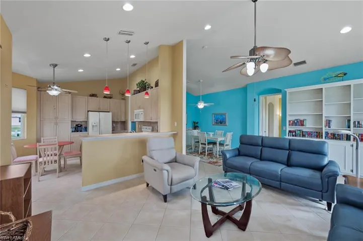 Living room featuring a ceiling fan, vaulted ceiling, recessed lighting, light tile patterned floors, and arched walkways