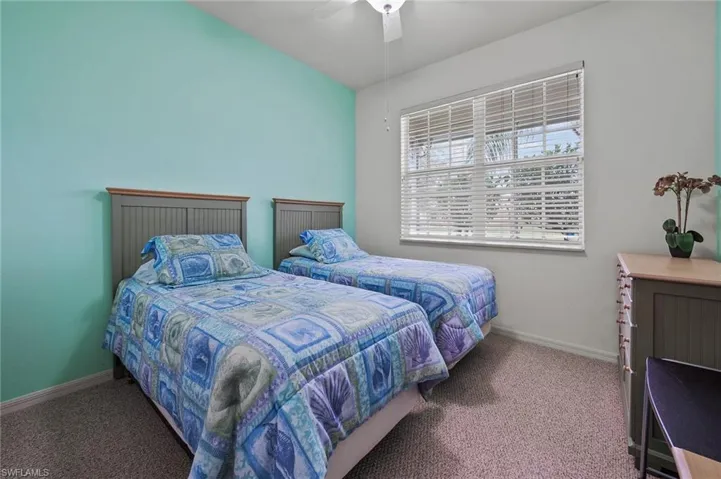 Carpeted bedroom featuring baseboards and ceiling fan