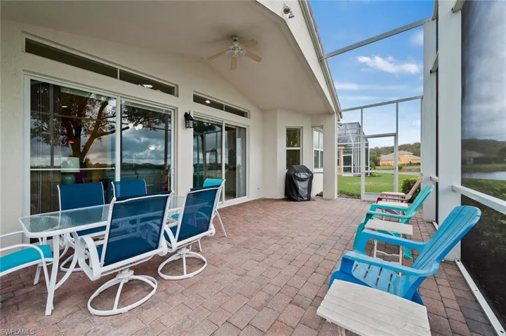 Sunroom with ceiling fan, outdoor dining space, a patio, and vaulted ceiling