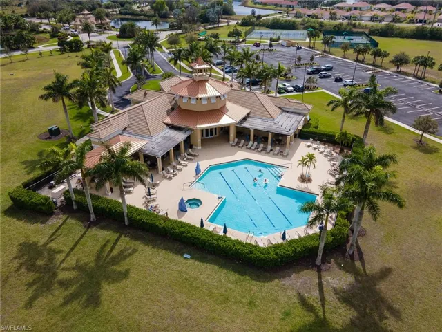 Drone / aerial view of a pool area and a nearby body of water
