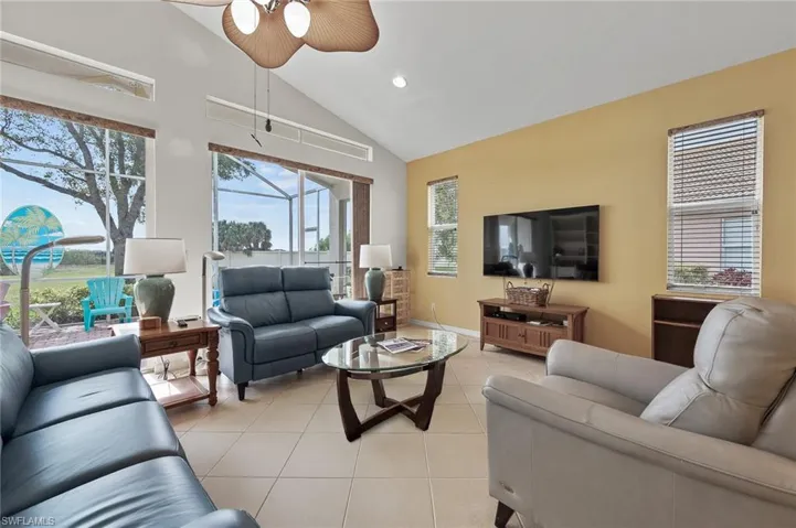 Living room with light tile patterned floors, a ceiling fan, recessed lighting, and high vaulted ceiling