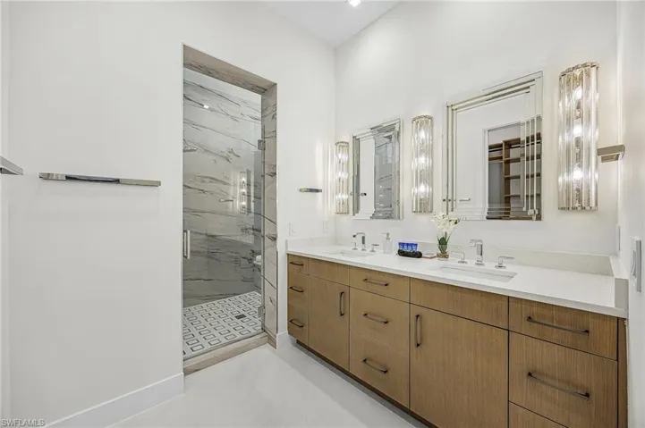 Bathroom featuring double vanity and a marble finish shower - Virtually Edited Image
