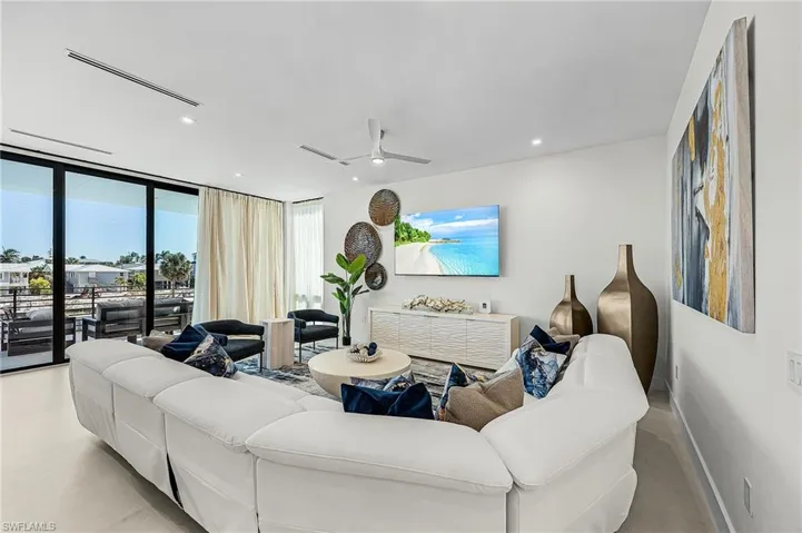 Living room featuring floor to ceiling windows, recessed lighting, and a ceiling fan - Virtually Edited Image